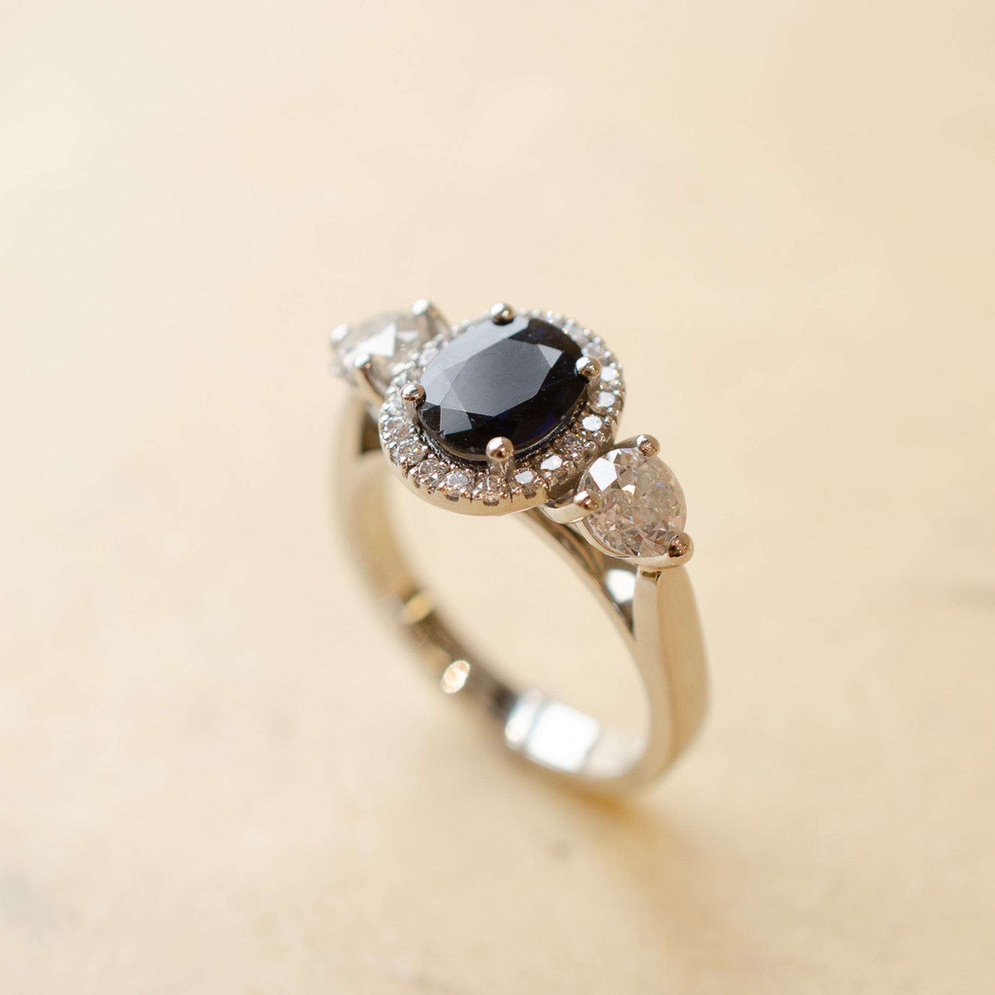 BlueOvalSapphire_DiamondHaloTrilogyRing_0000s_0001_BlueOvalSapphire_DiamondHaloTrilogyRing5.jpg