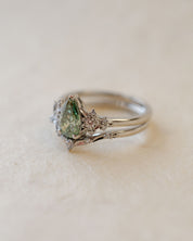 Silver ring with a green gemstone on a light beige background