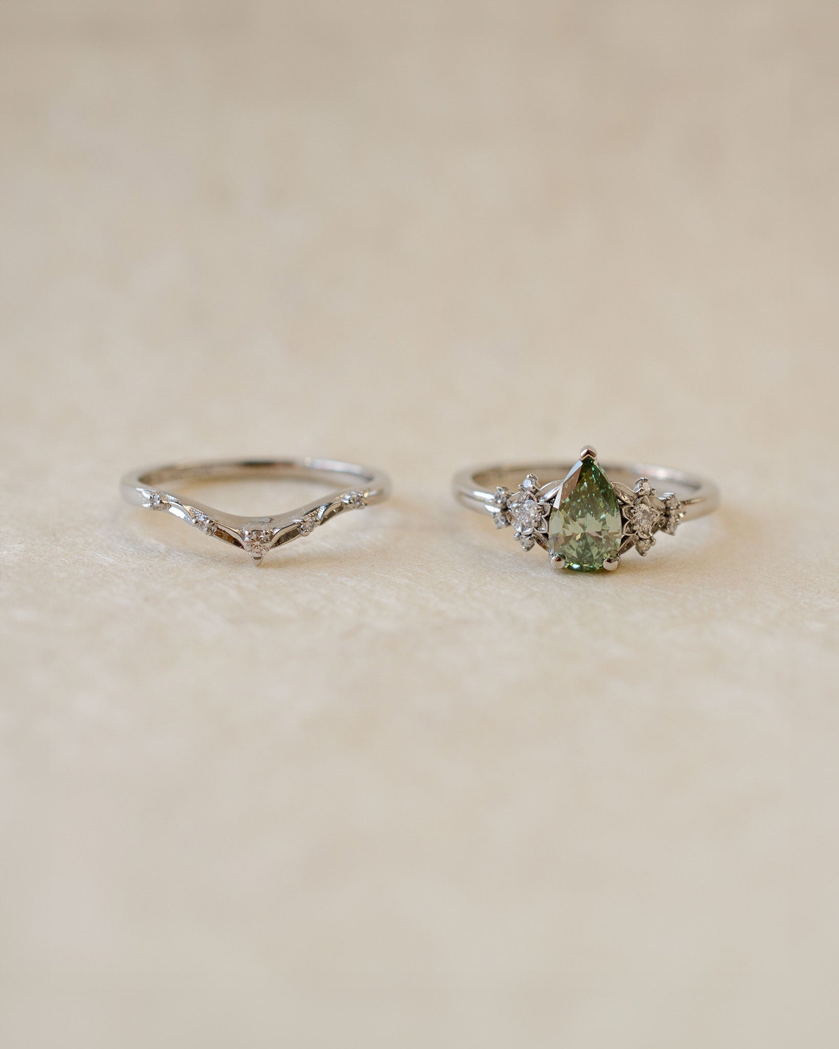 Two silver rings with gemstones on a beige background