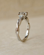Platinum twist shoulder engagement ring with diamond