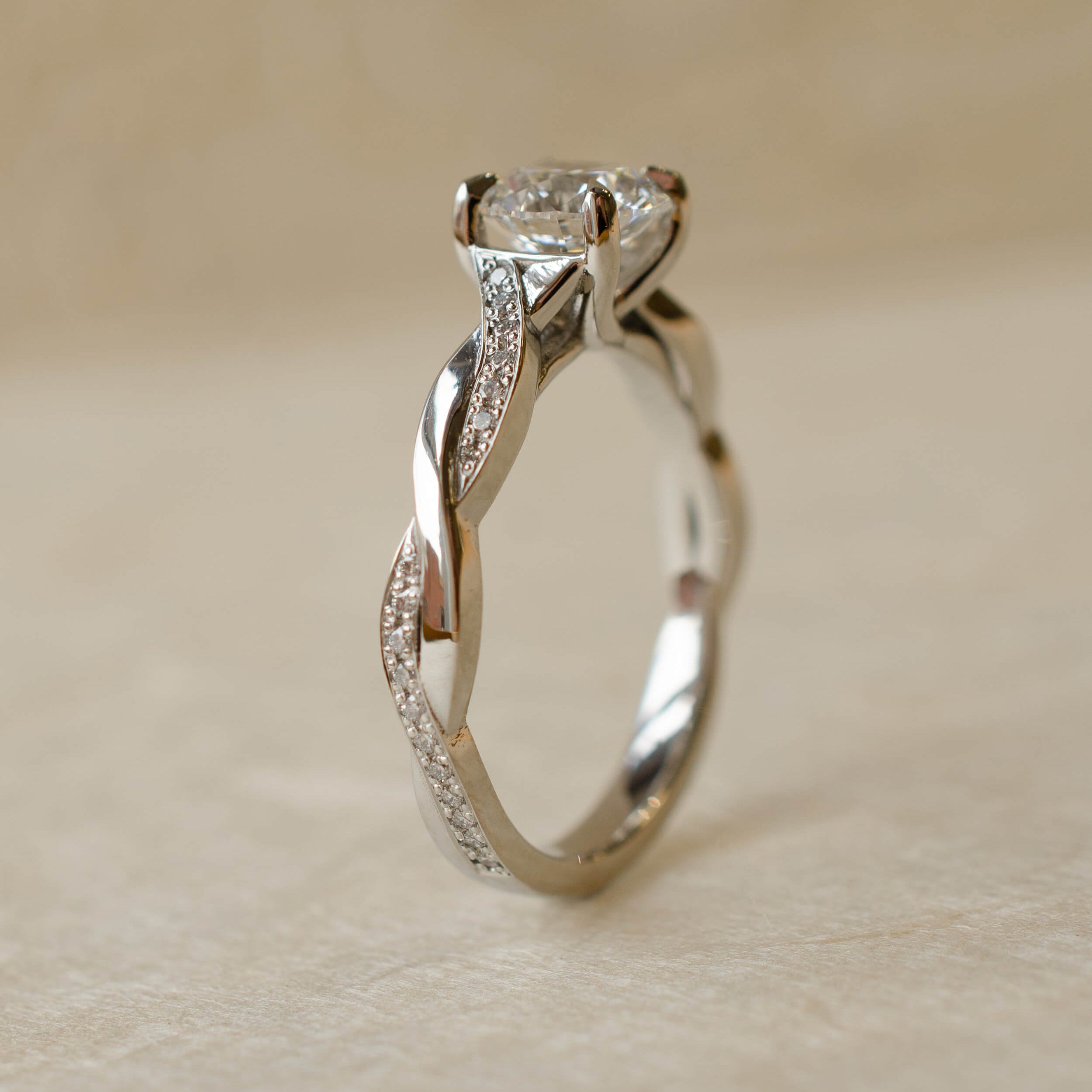 Platinum twist shoulder engagement ring with diamond