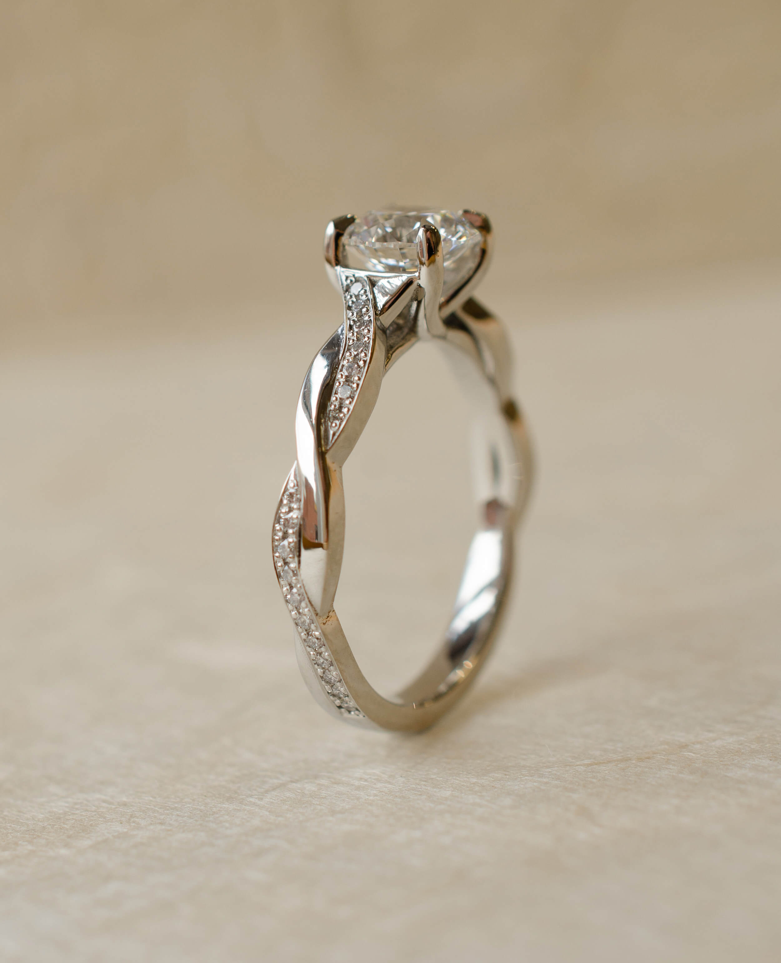 Platinum twist shoulder engagement ring with diamond