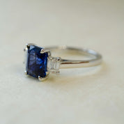 Ring with a blue gemstone and diamond on a light background