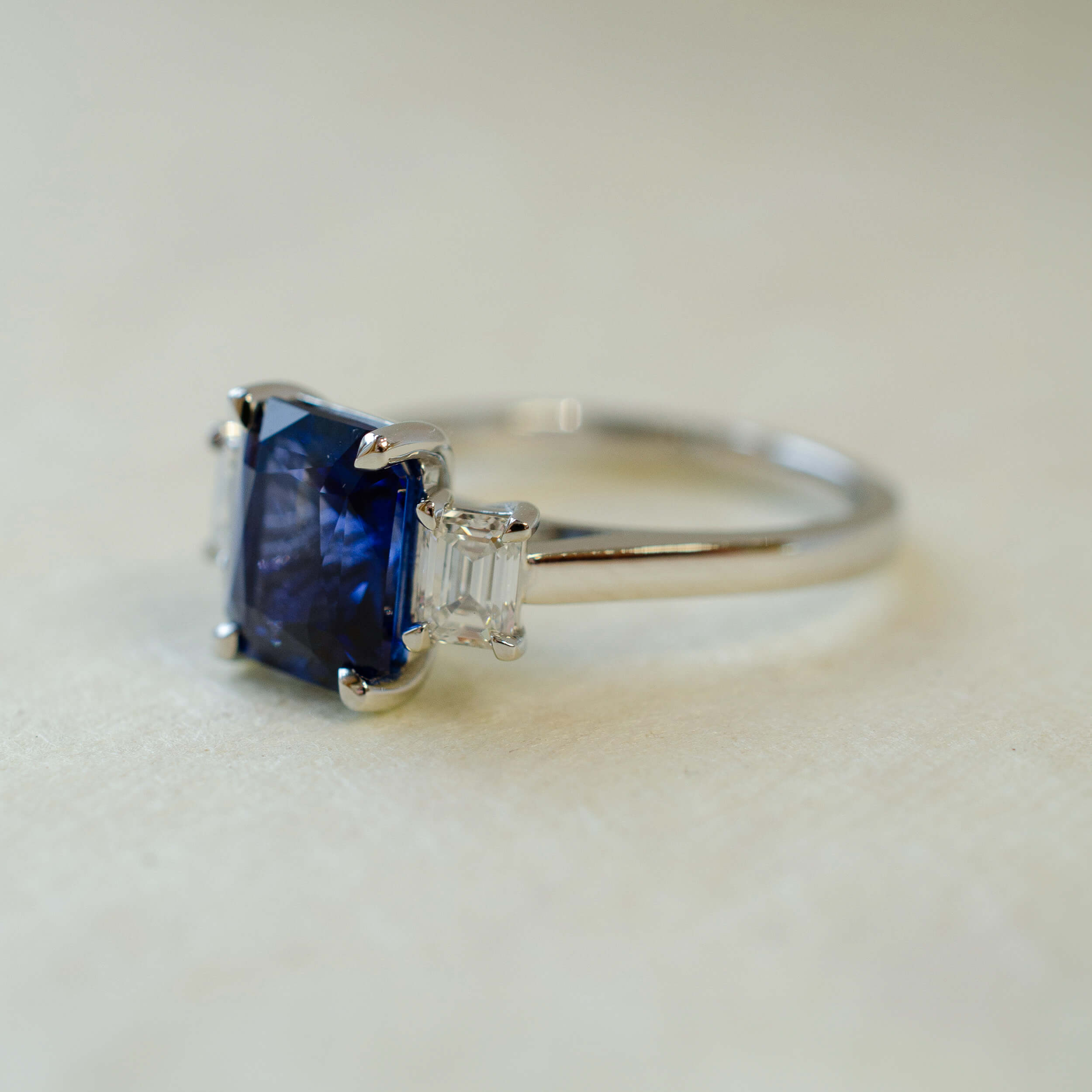 Ring with a blue gemstone and diamond on a light background