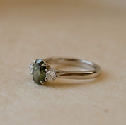 platinum ring with green lab-grown diamond and two white diamonds 