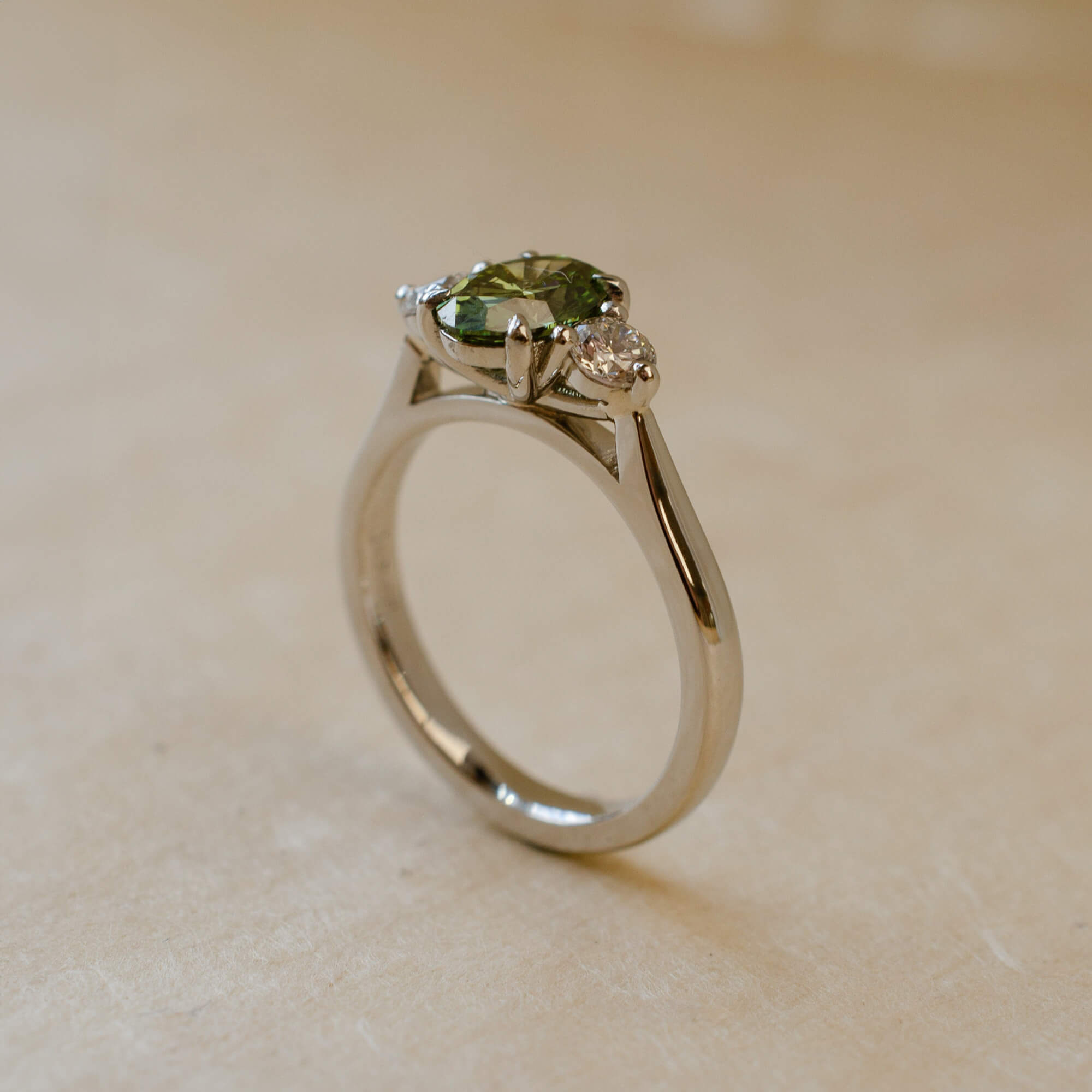 platinum trilogy ring with green lab-grown diamond