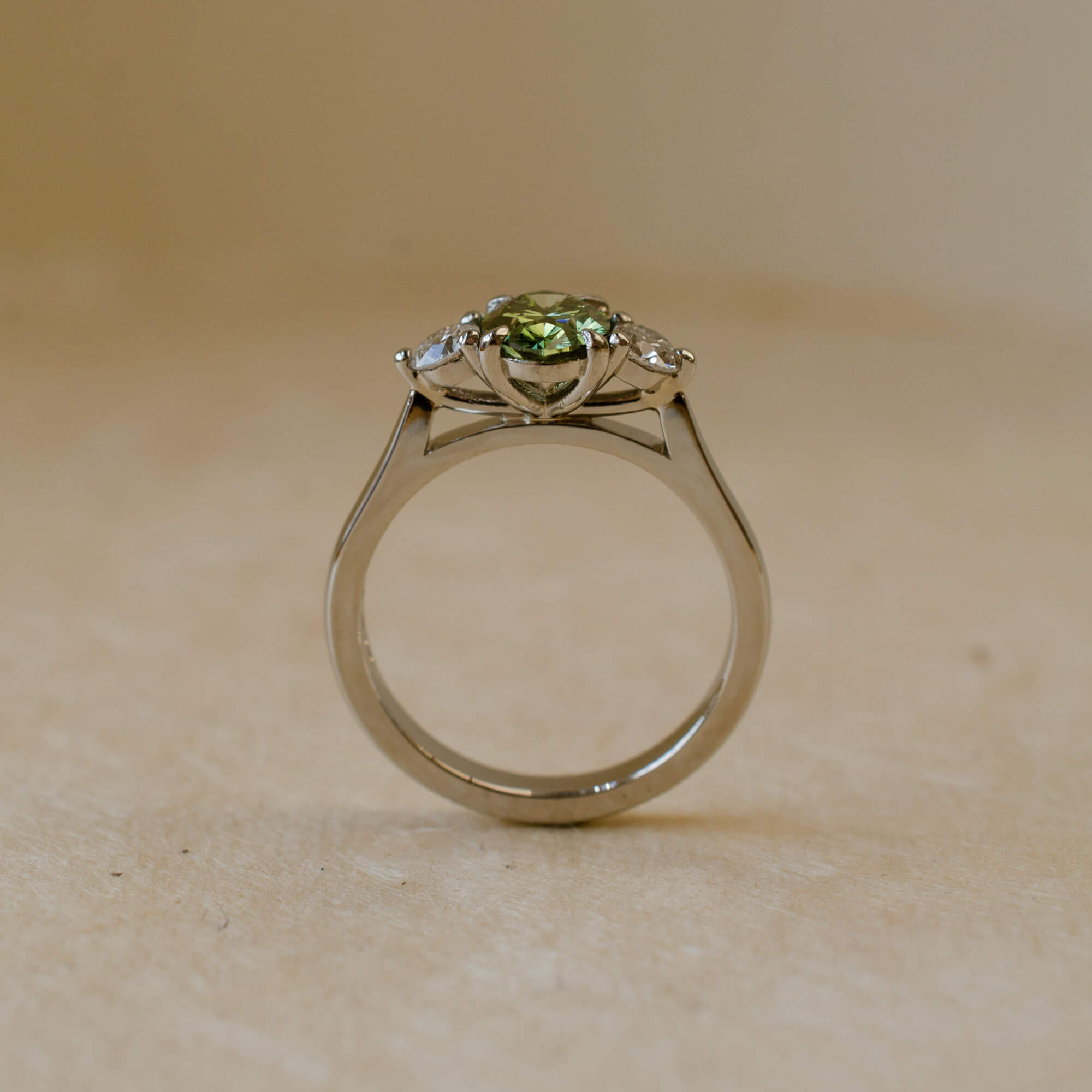 three stone ring with green lab-grown diamond and white diamonds