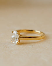 Gold ring with a diamond on a beige background