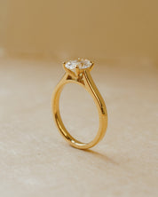 Gold ring with a diamond on a beige background