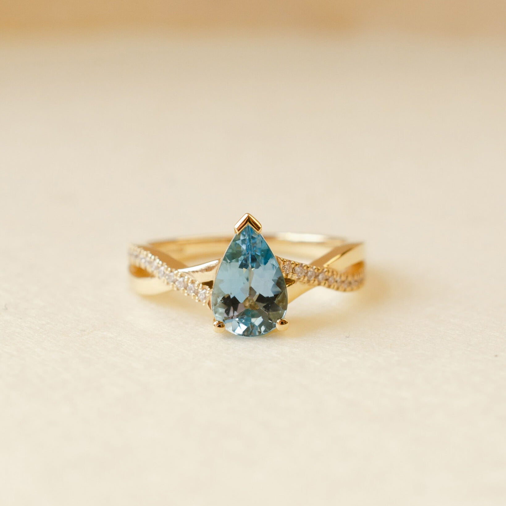 yellow gold ring with pear cut aquamarine and twist shoulders set with diamonds 