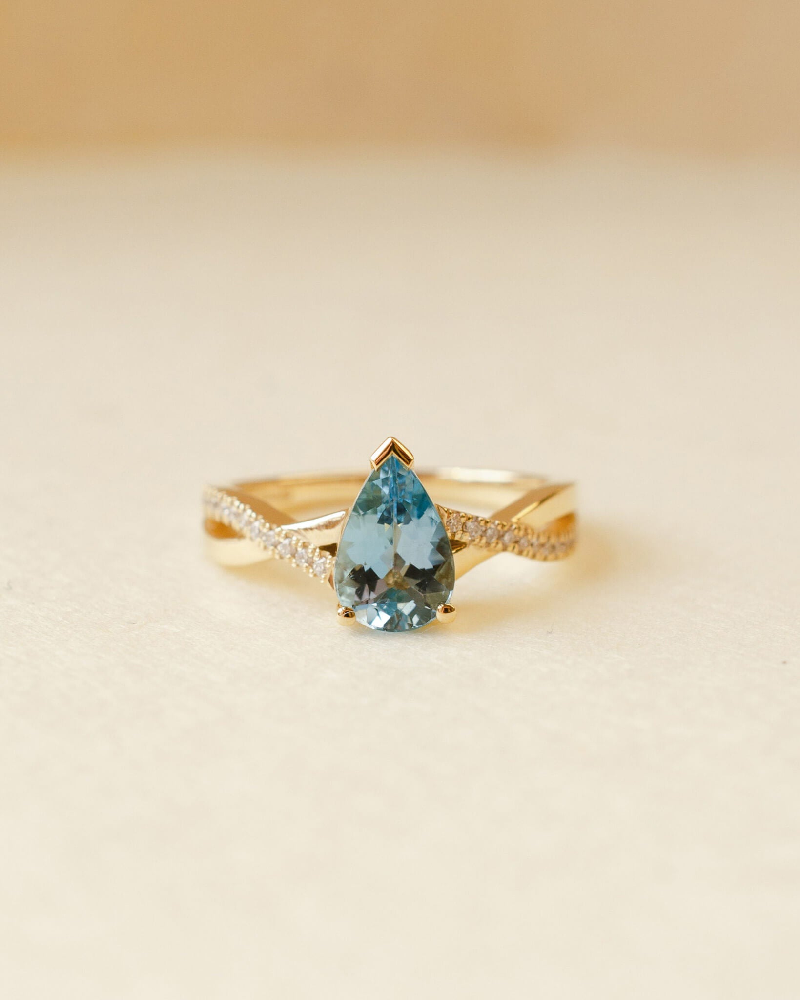 yellow gold ring with pear cut aquamarine and twist shoulders set with diamonds 