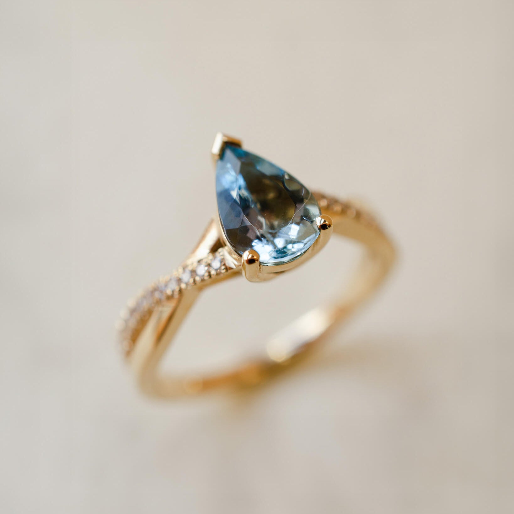 yellow gold ring with pear cut aquamarine and twist shoulders set with diamonds 