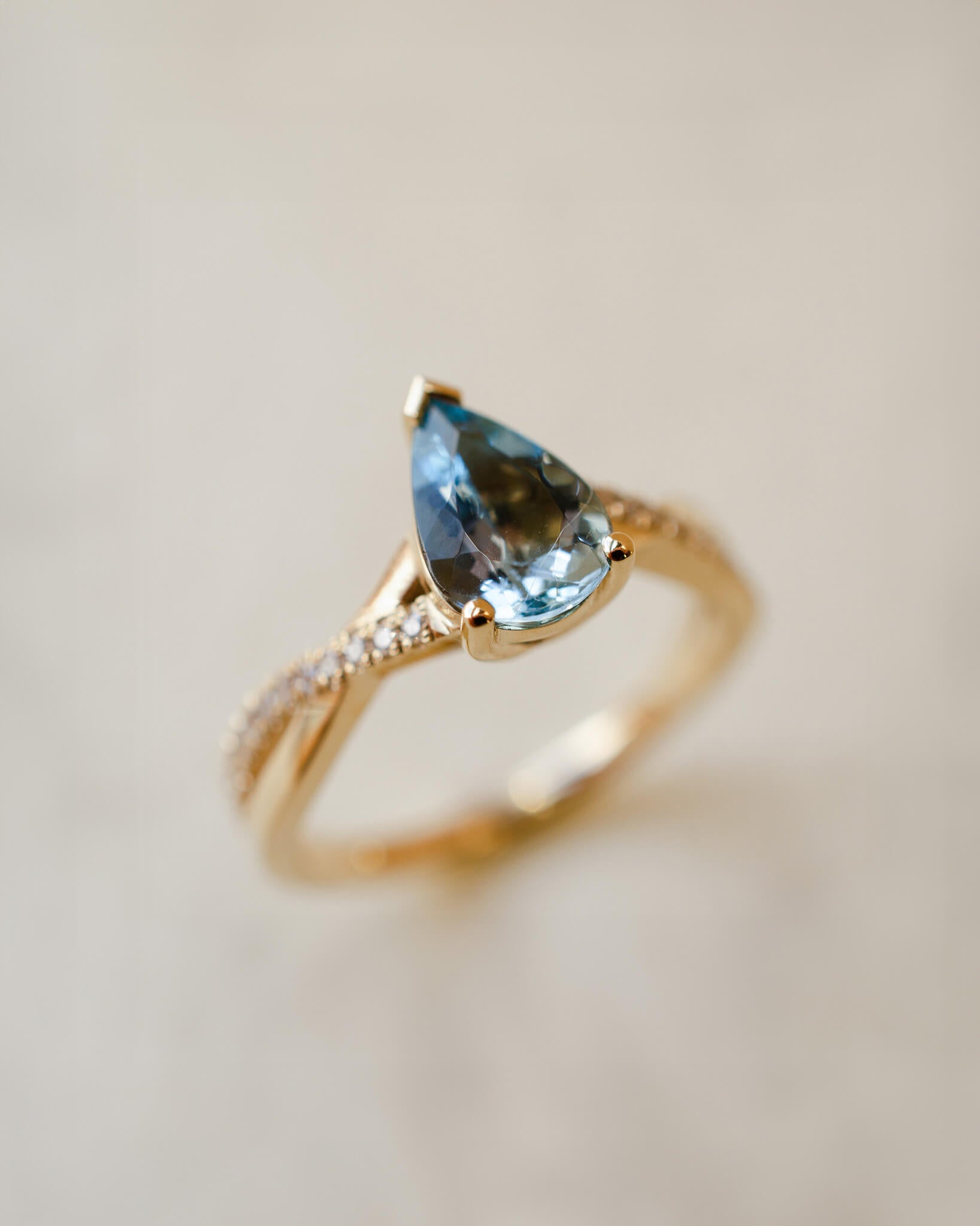 yellow gold ring with pear cut aquamarine and twist shoulders set with diamonds 