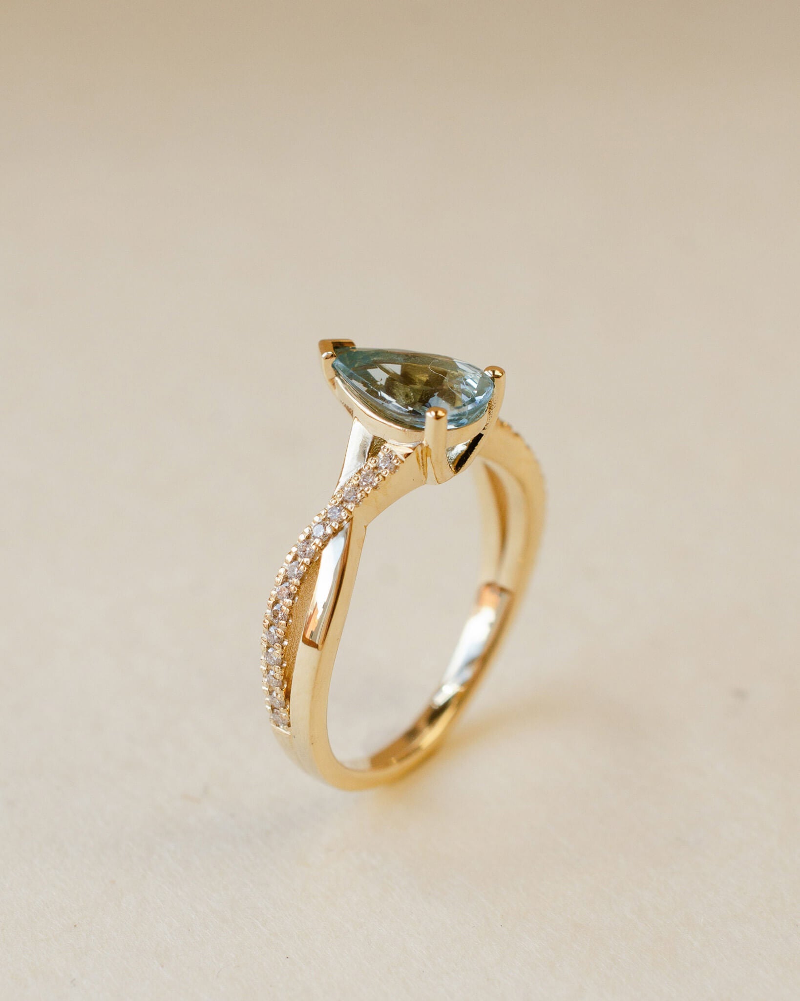 yellow gold ring with pear cut aquamarine and twist shoulders set with diamonds 