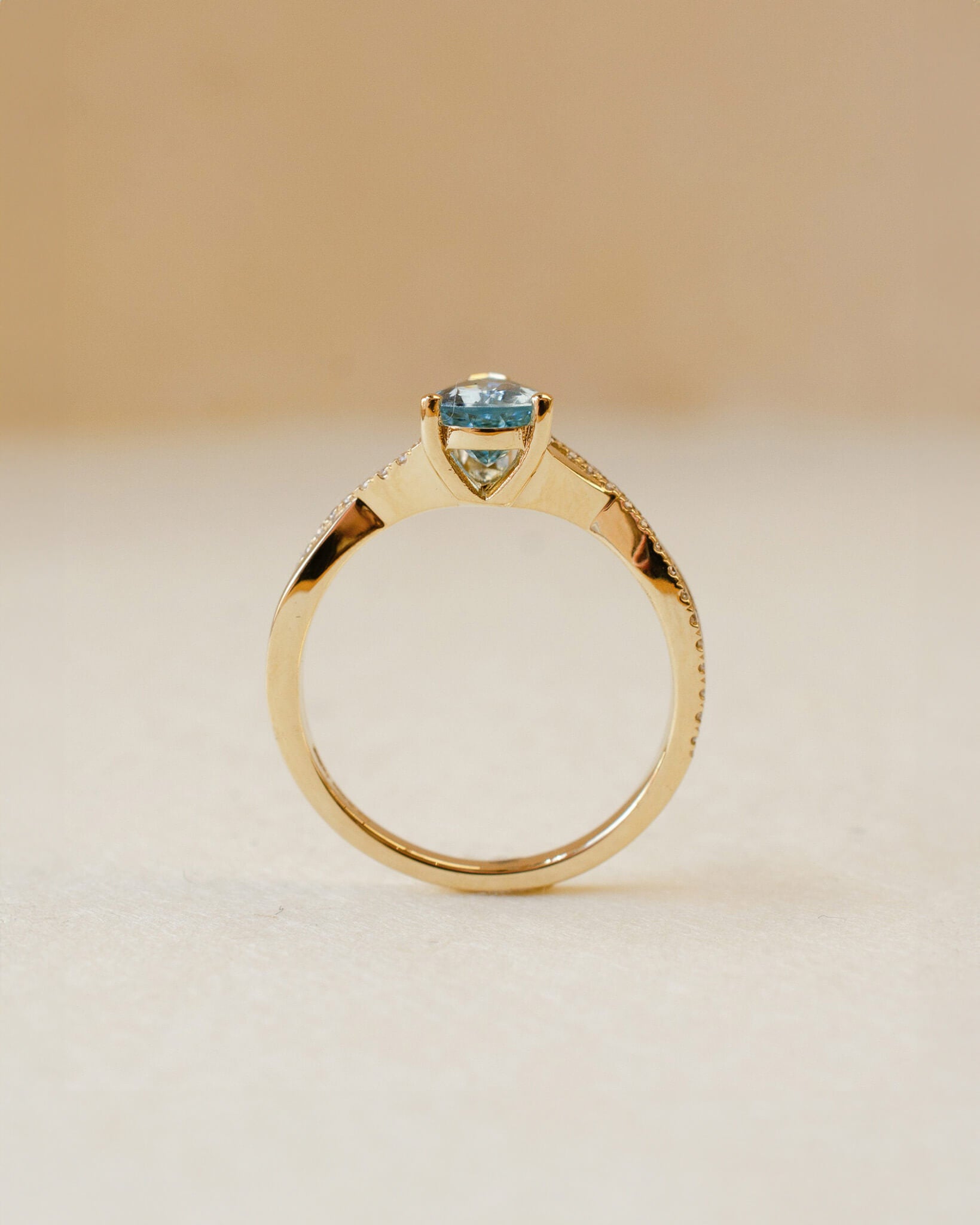 yellow gold ring with pear cut aquamarine and twist shoulders set with diamonds 