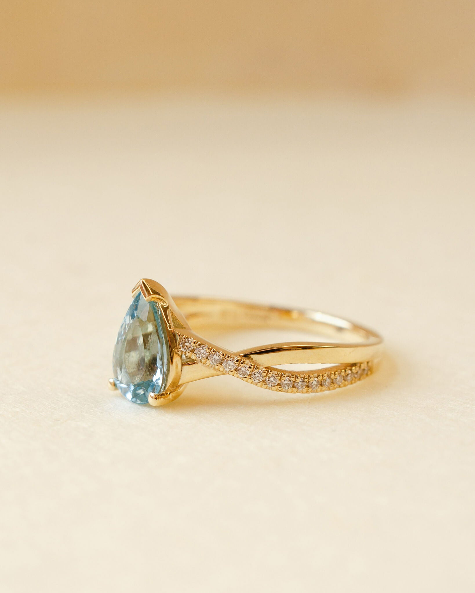 yellow gold ring with pear cut aquamarine and twist shoulders set with diamonds 