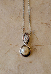 pearl diamond and platinum figure of eight pendant 