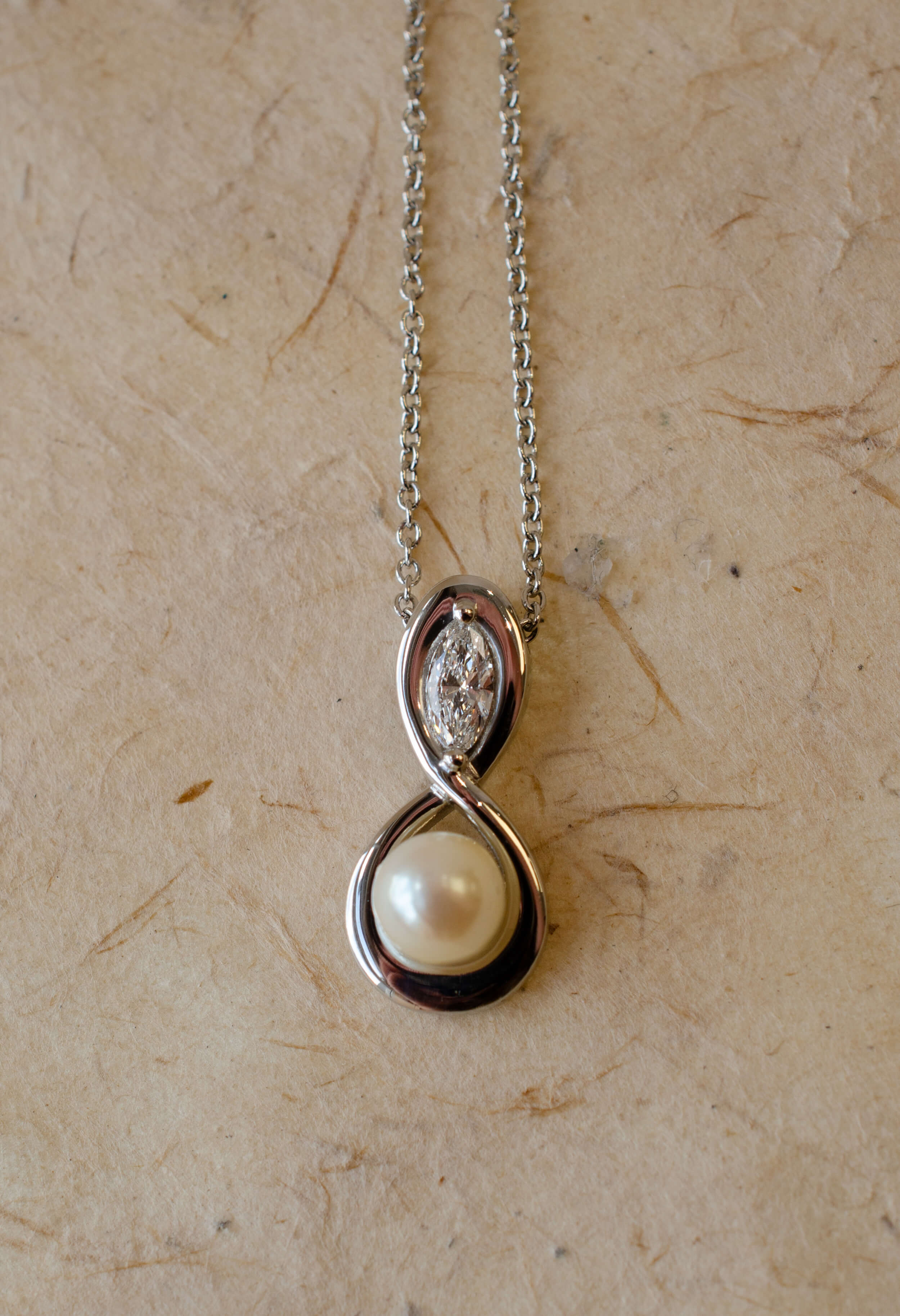 pearl diamond and platinum figure of eight pendant 