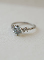 blue diamond delicate engagement ring with scatter set diamond shoulders