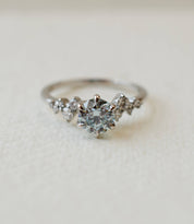 platinum and blue diamond engagement ring with scattered diamond shoulders