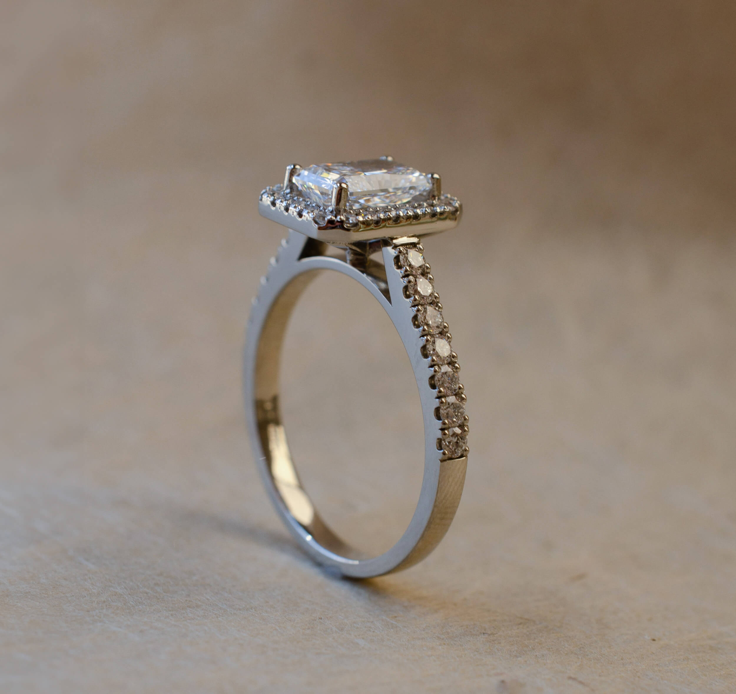 halo style engagement ring with radiant cut diamond