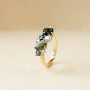 gold ring with diamonds and green, blue and teal sapphires
