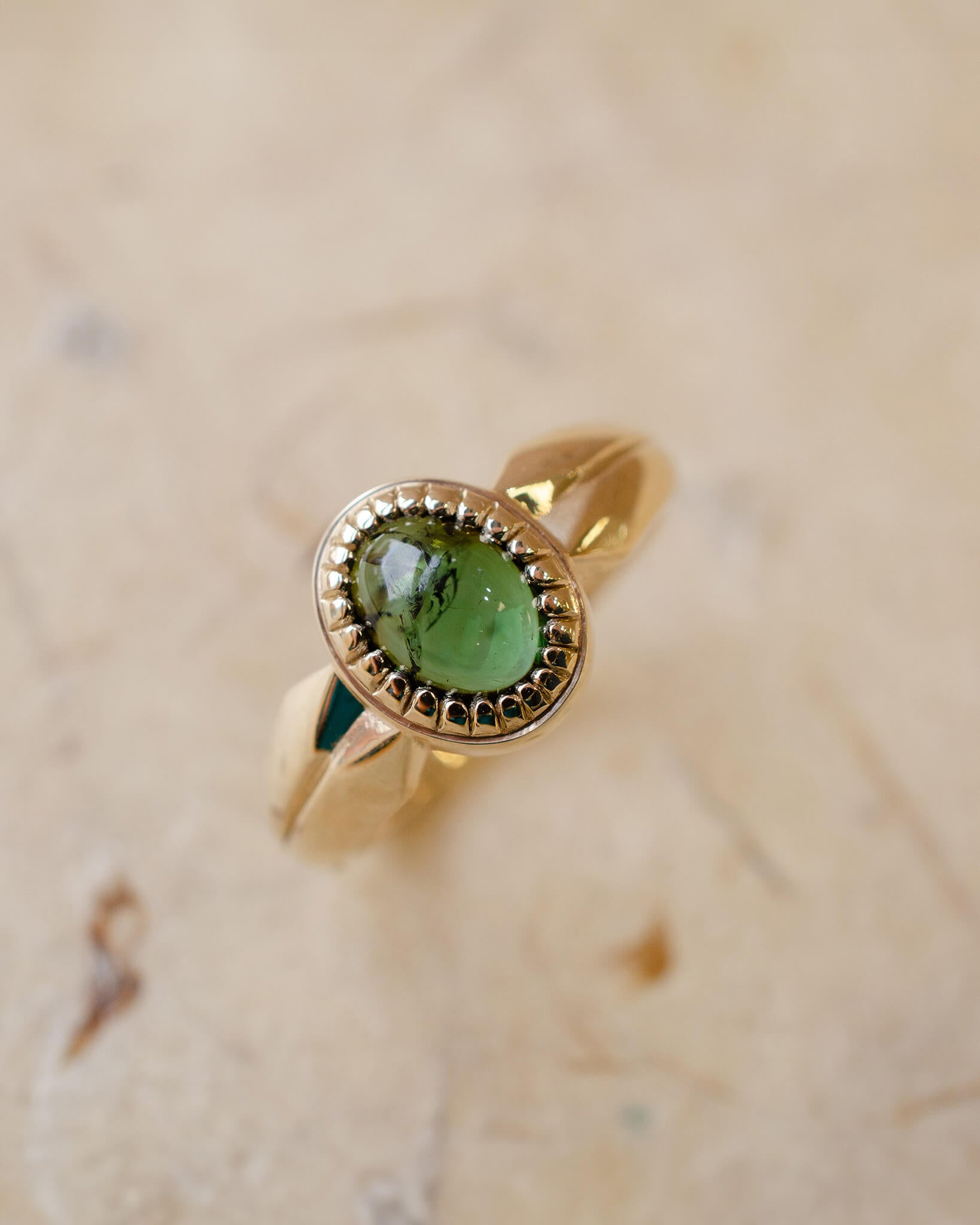 yellow gold alternative engagement ring with tourmaline cabochon