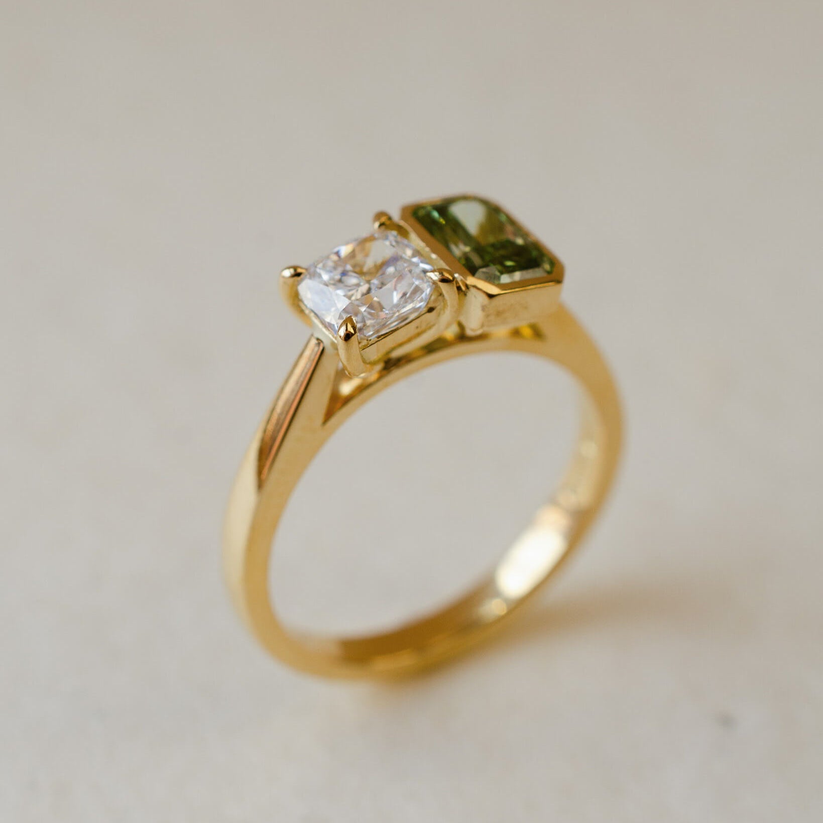 A two stone engagement ring with a white and a green lab-grown diamond