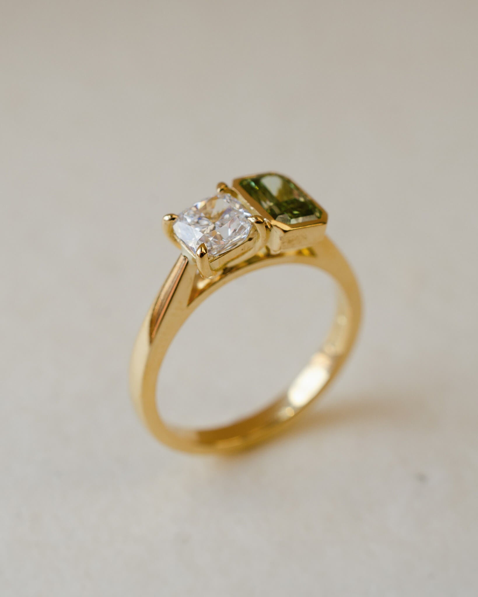 A two stone engagement ring with a white and a green lab-grown diamond