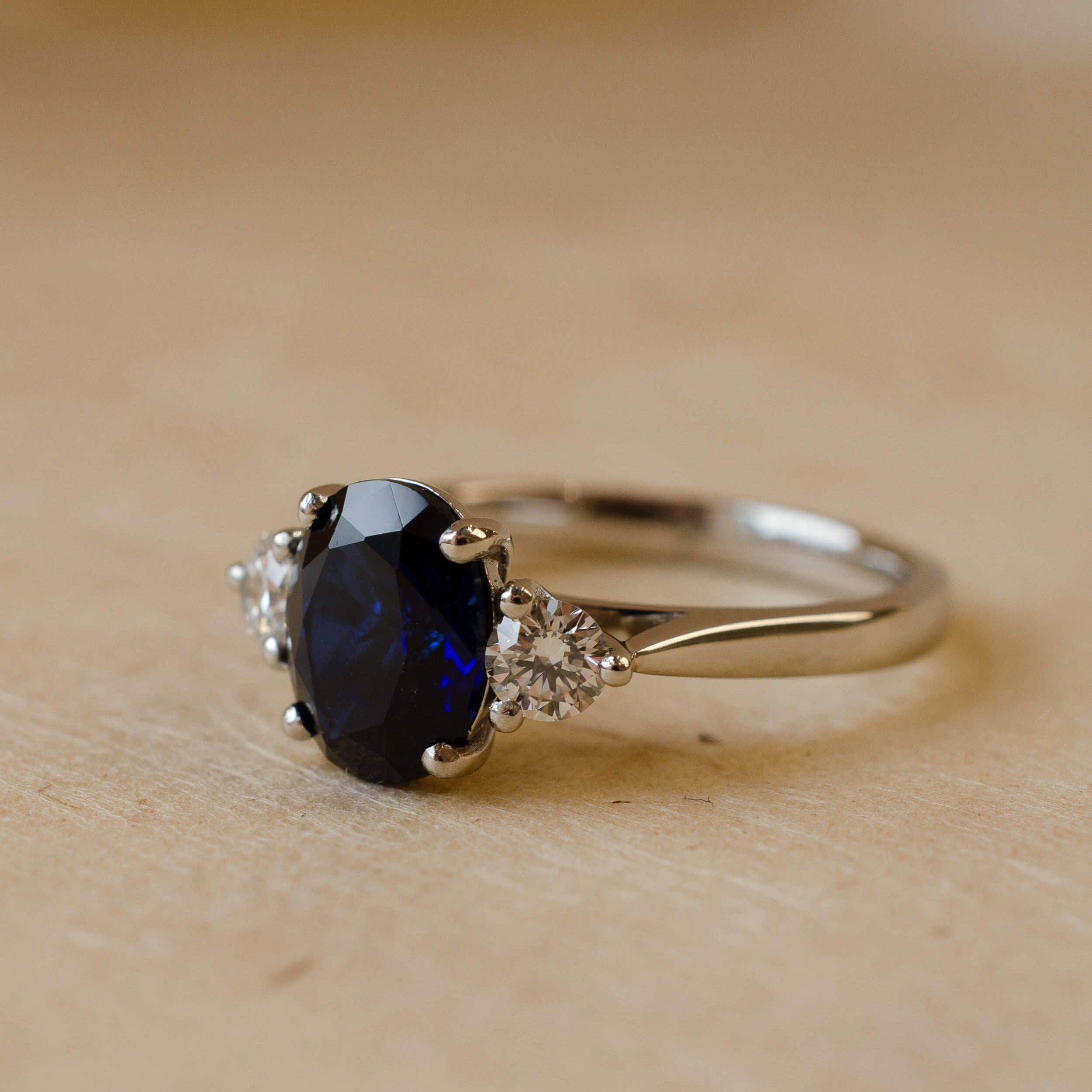 oval cut blue sapphire and diamond trilogy ring in platinum