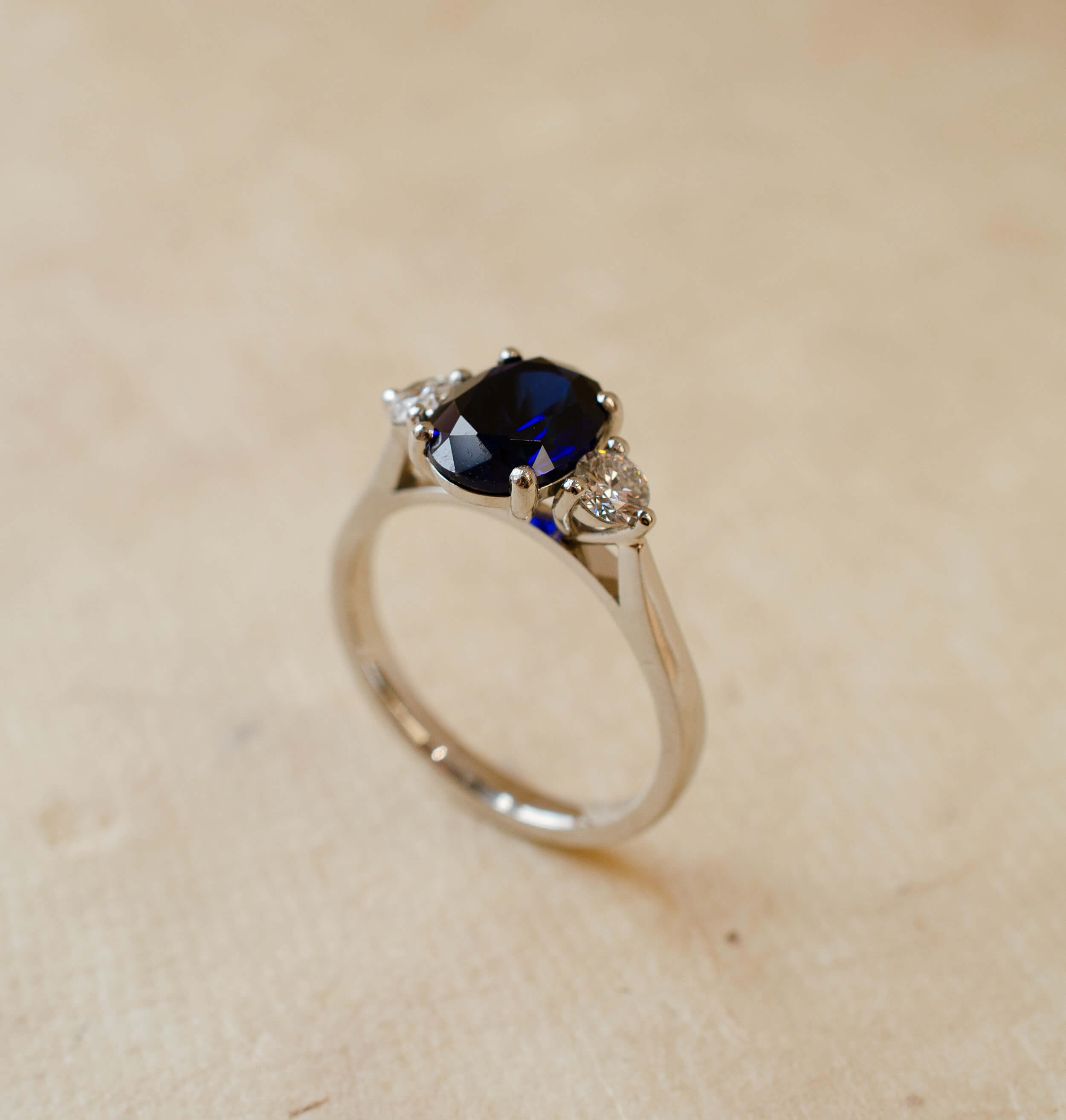 oval cut blue sapphire and round diamond trilogy ring in platinum