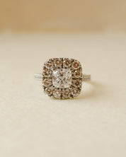 A diamond cluster halo style ring with a cushion cut centre stone