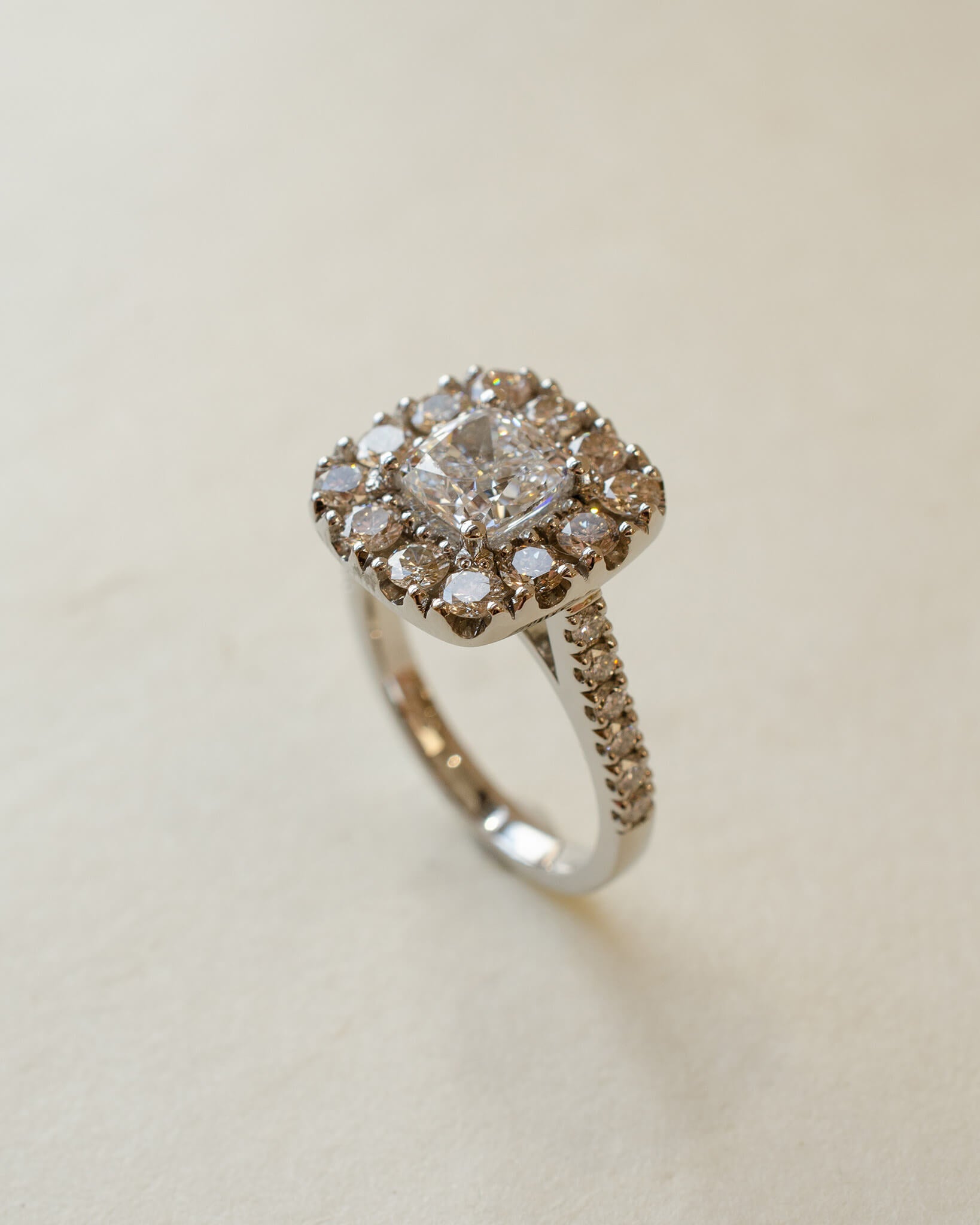 A diamond cluster halo style ring with a cushion cut centre stone