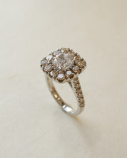 A diamond cluster halo style ring with a cushion cut centre stone