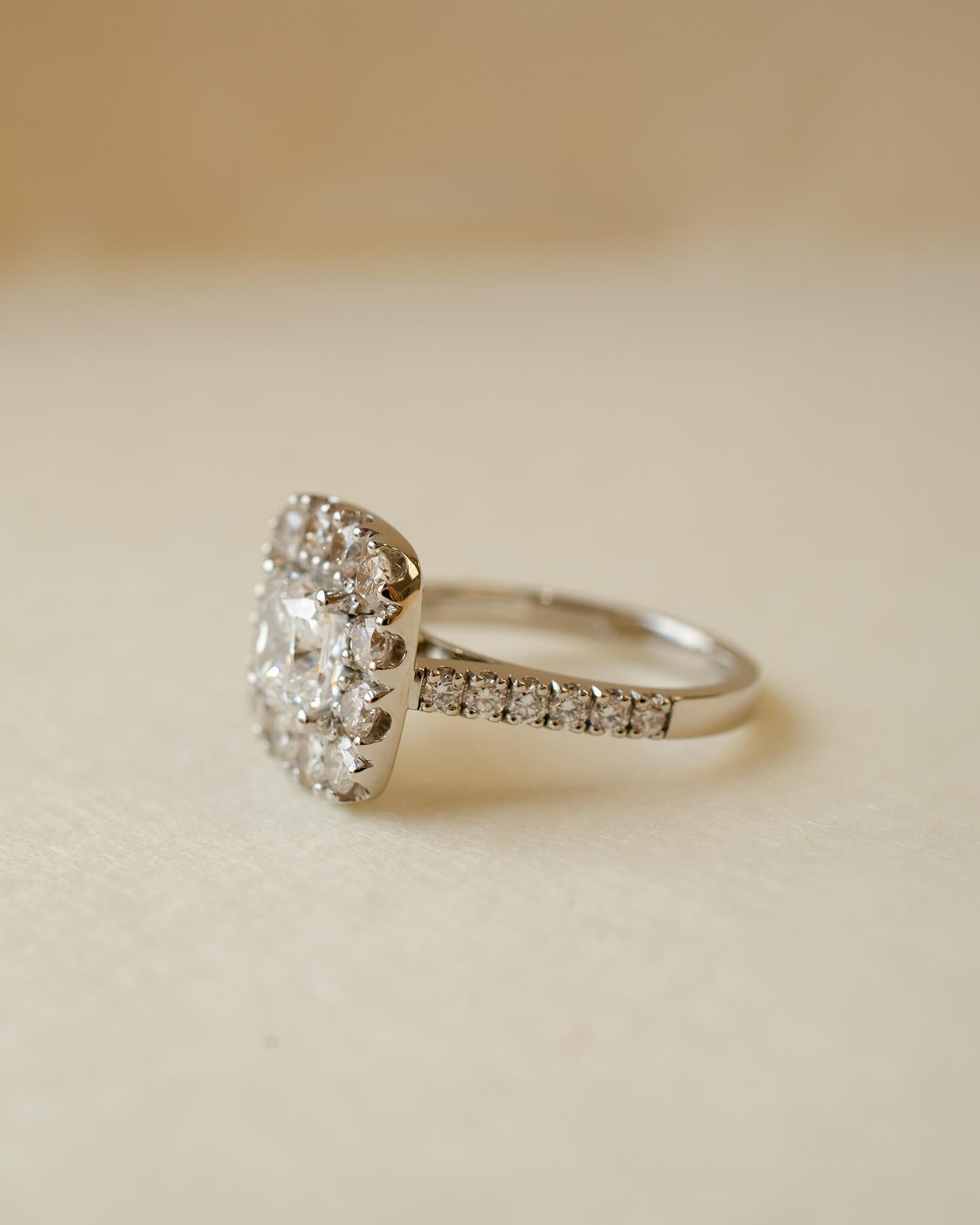 A diamond cluster halo style ring with a cushion cut centre stone