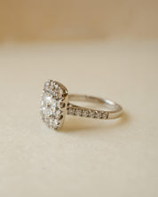 A diamond cluster halo style ring with a cushion cut centre stone