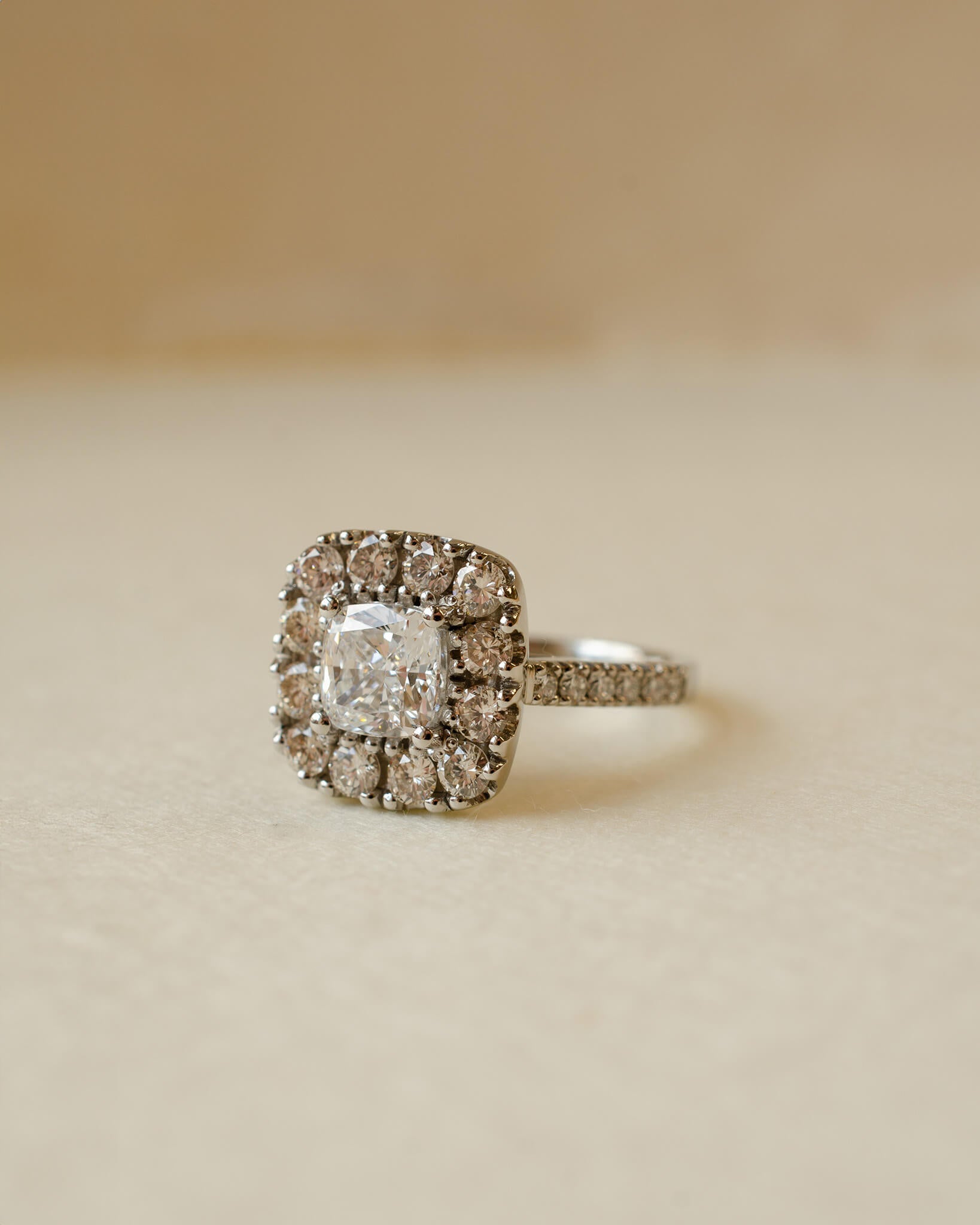 A diamond cluster halo style ring with a cushion cut centre stone