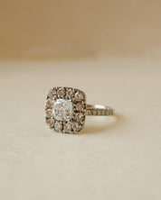 A diamond cluster halo style ring with a cushion cut centre stone
