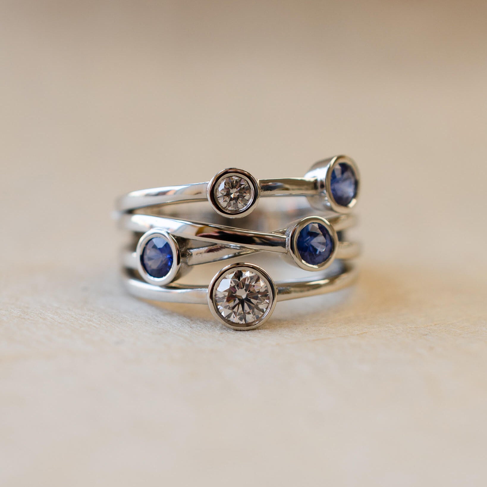 A platinum bubble ring with white diamonds and blue sapphires
