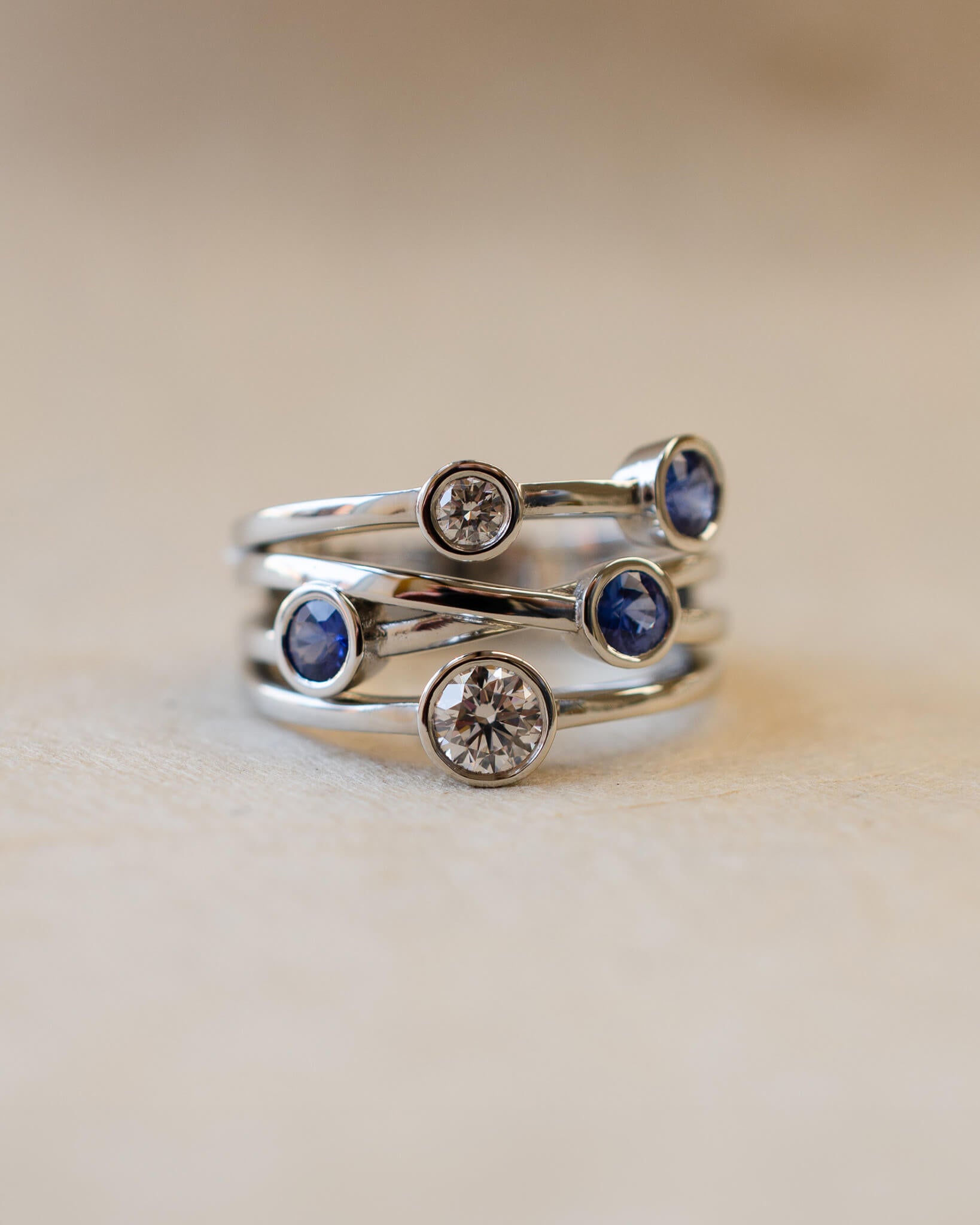 A platinum bubble ring with white diamonds and blue sapphires