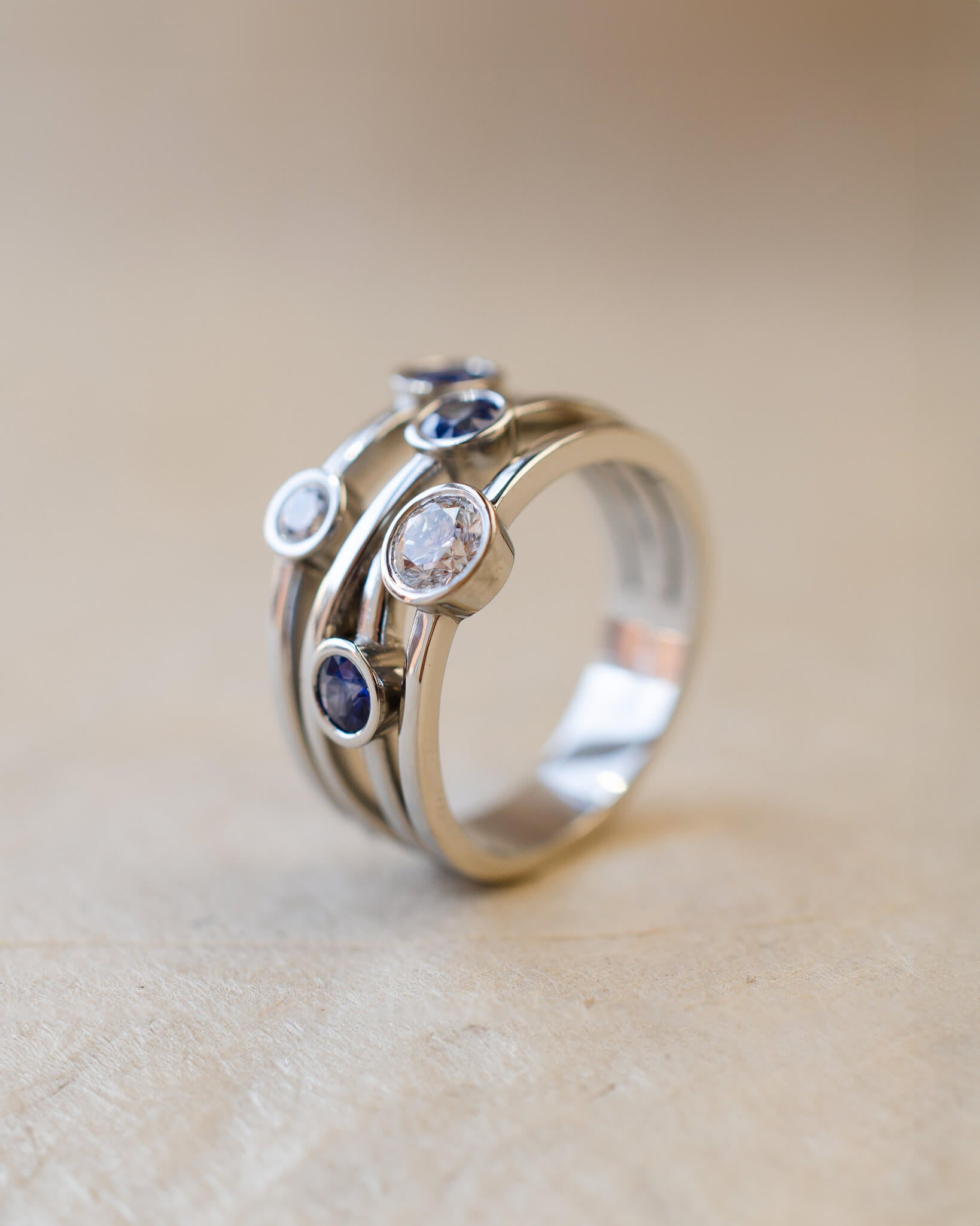 A platinum bubble ring with white diamonds and blue sapphires