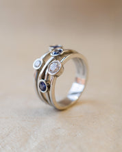 A platinum bubble ring with white diamonds and blue sapphires