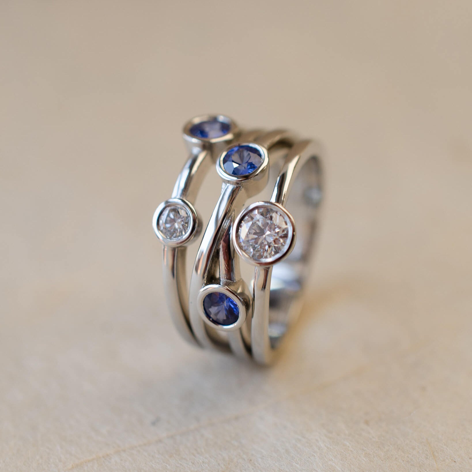 A platinum bubble ring with white diamonds and blue sapphires