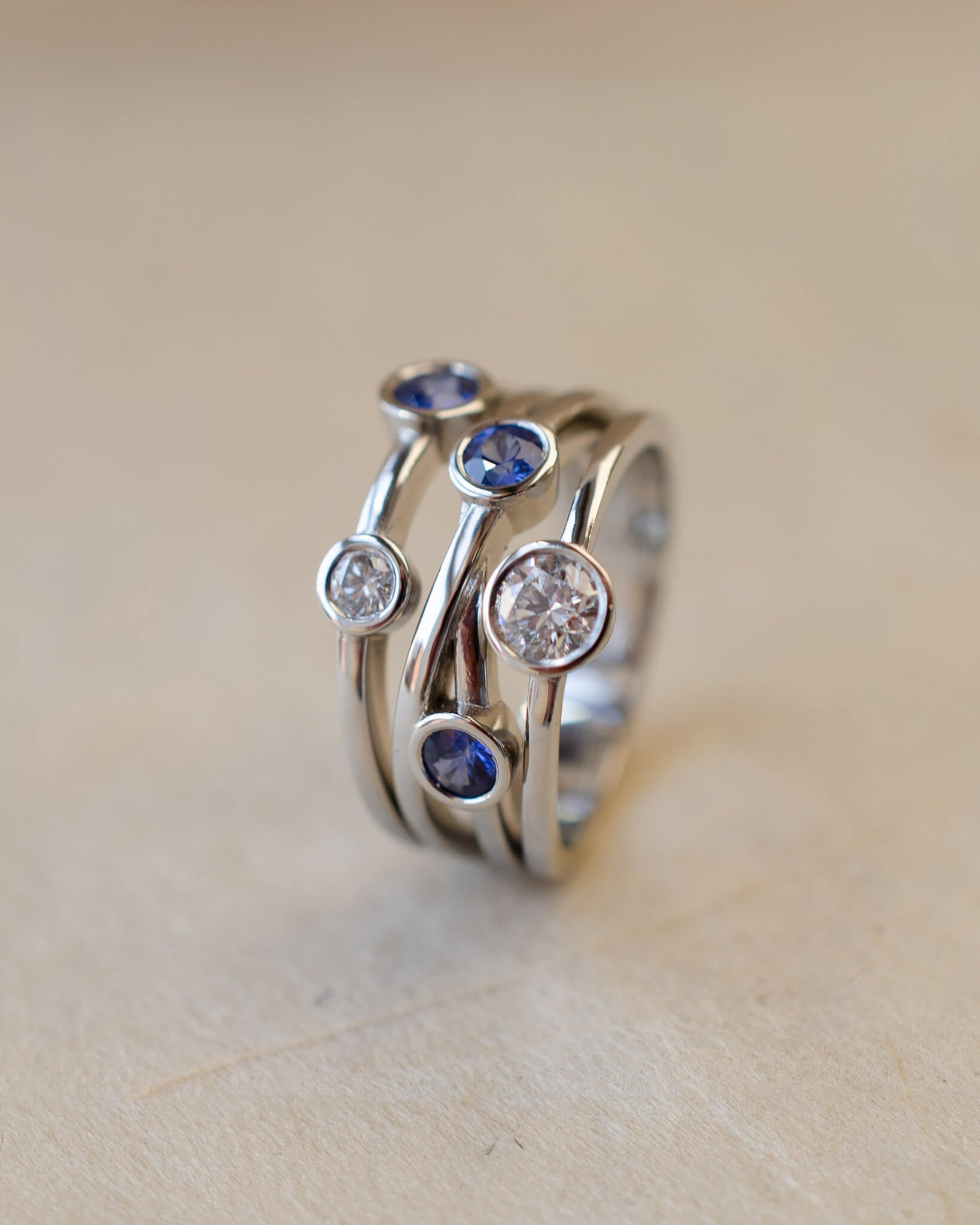 A platinum bubble ring with white diamonds and blue sapphires