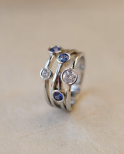 A platinum bubble ring with white diamonds and blue sapphires