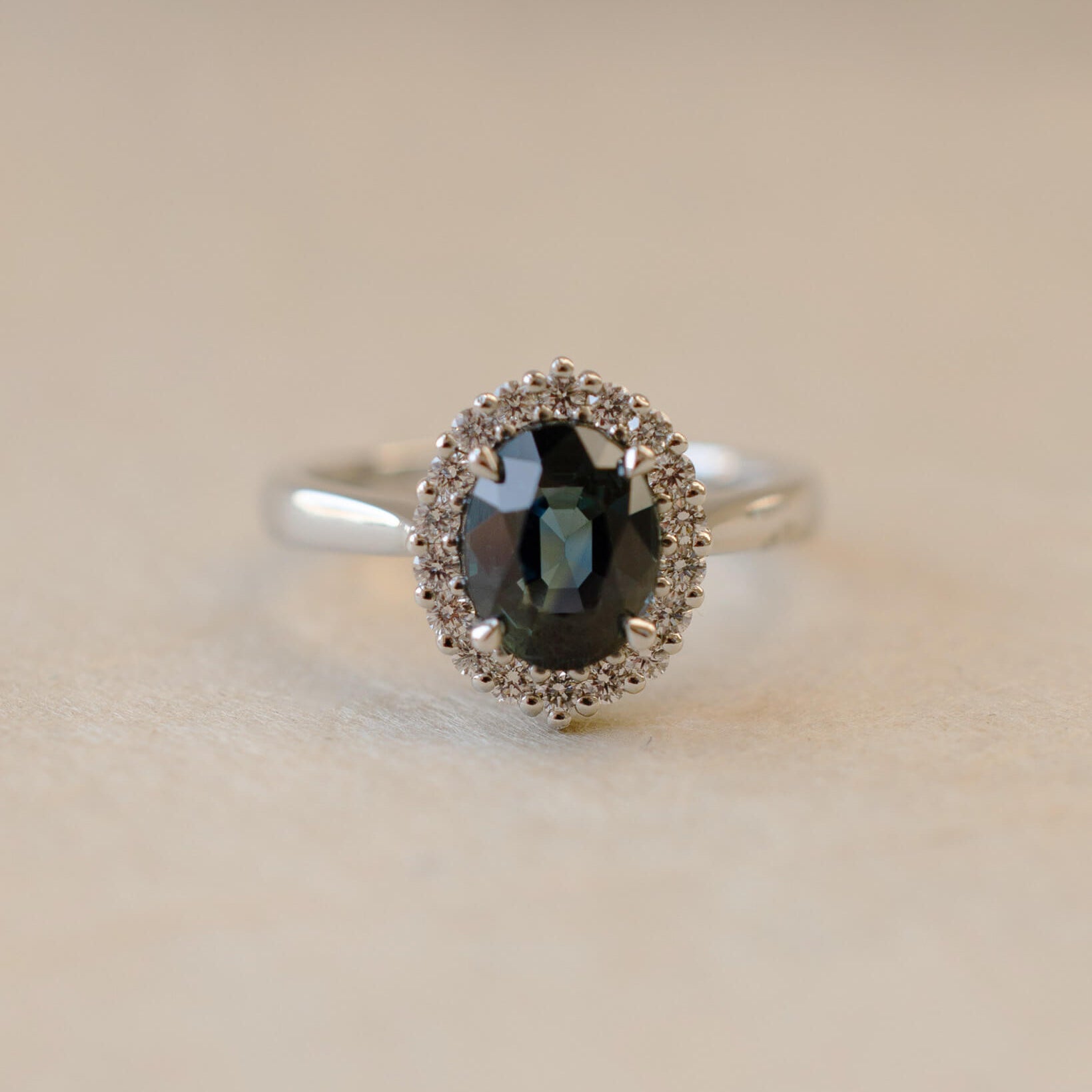 Teal sapphire and diamond cluster style ring