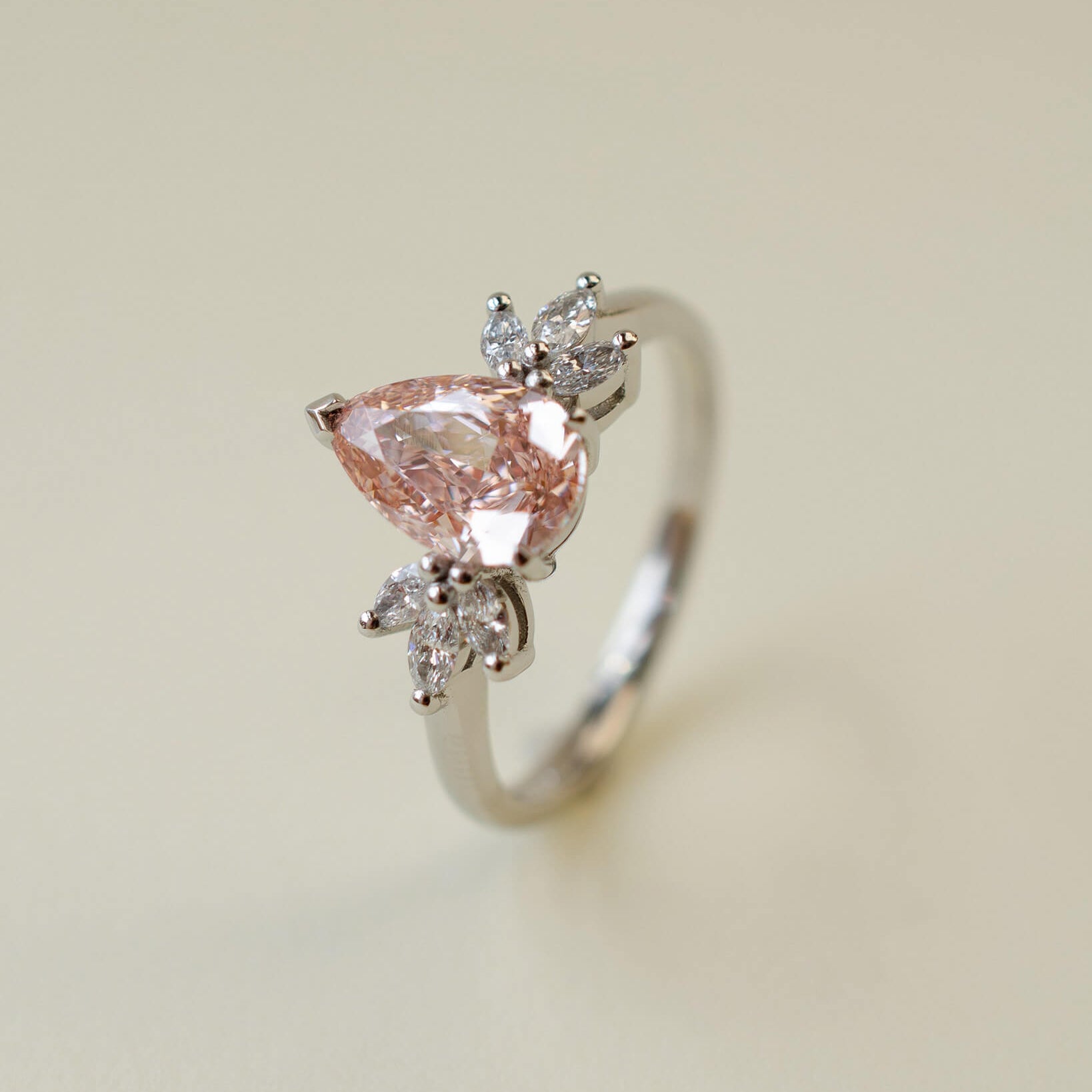 Pink pear cut lab-grown diamond ring with marquise diamond side stones