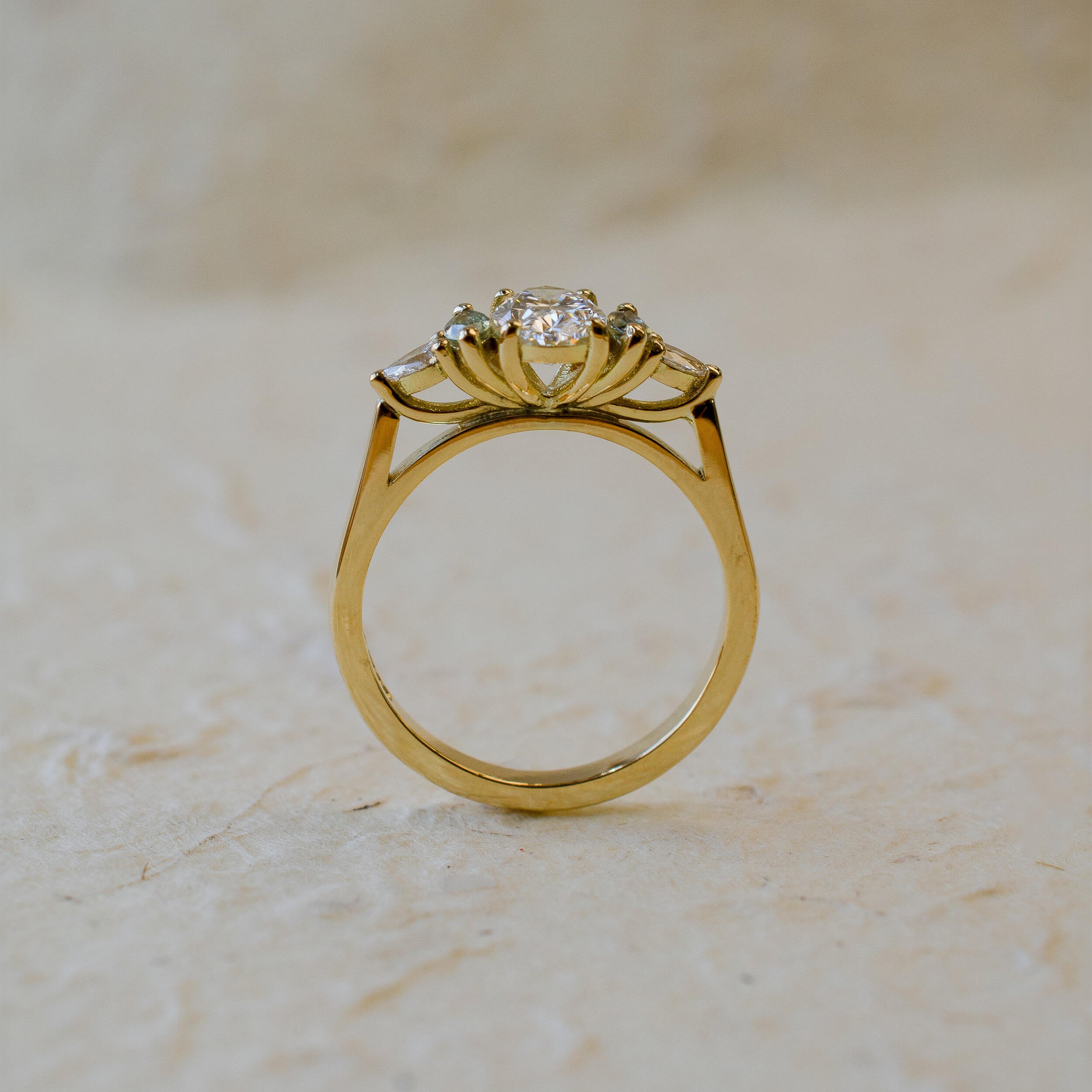 18ct yellow gold engagement ring with oval diamond and green marquise sapphires