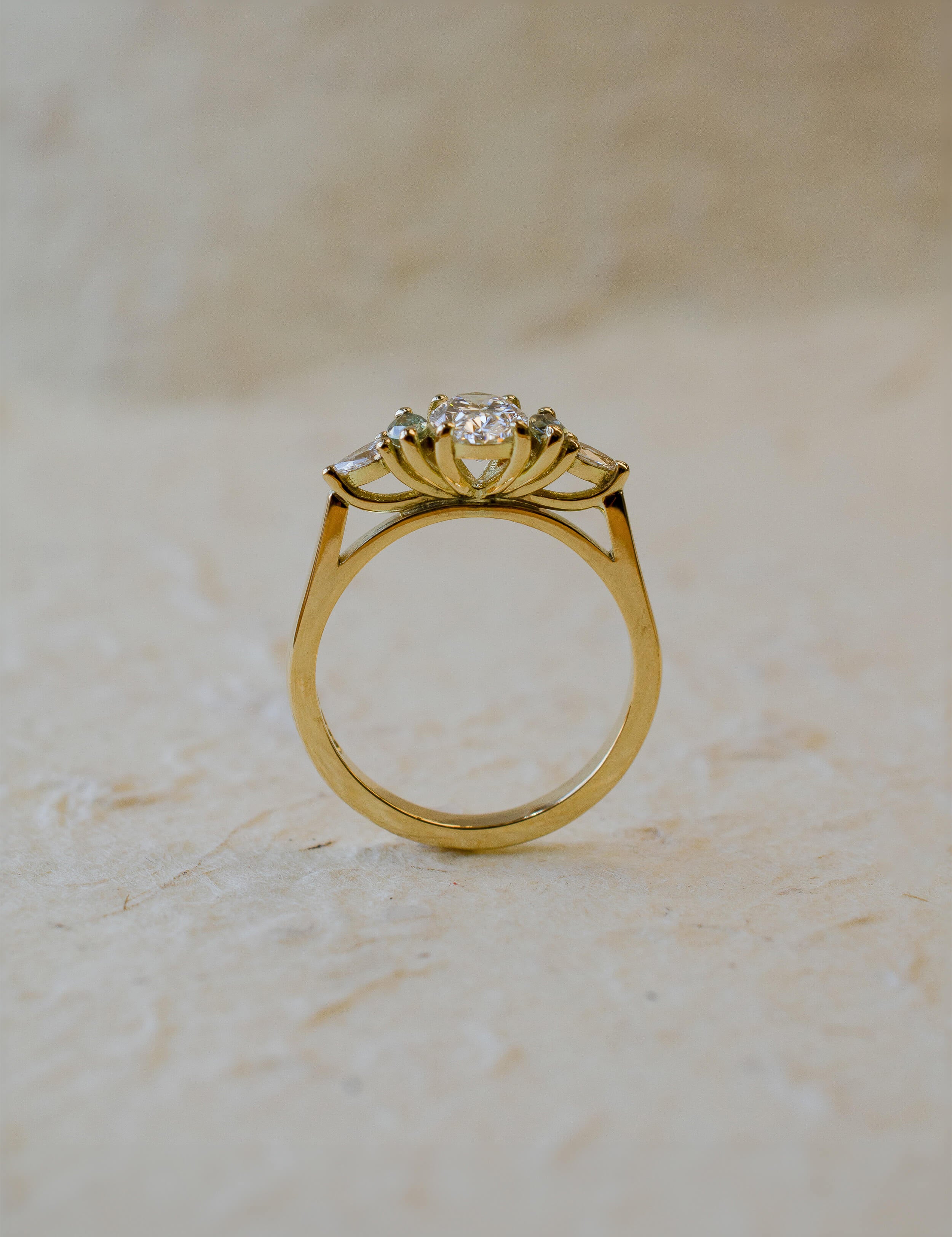 18ct yellow gold engagement ring with oval diamond and green marquise sapphires