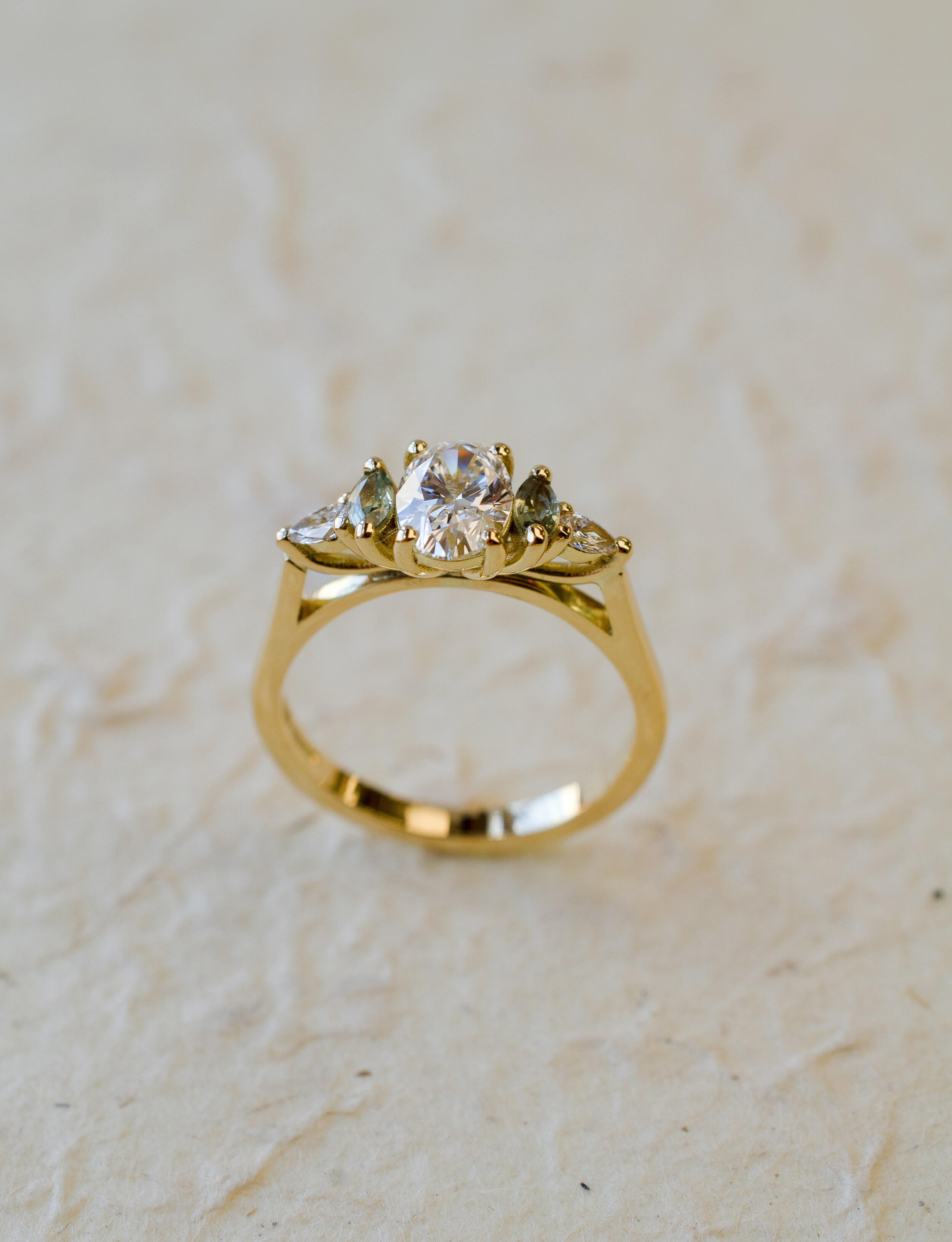 gold oval diamond engagement ring with marquise sapphire side stones